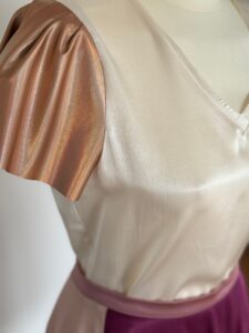 Beige-weißes Kleid aus glänzendem Stoff – elegant und modern.