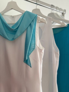 Elegante weiße Bluse kombiniert mit einem türkisfarbenen Schal.